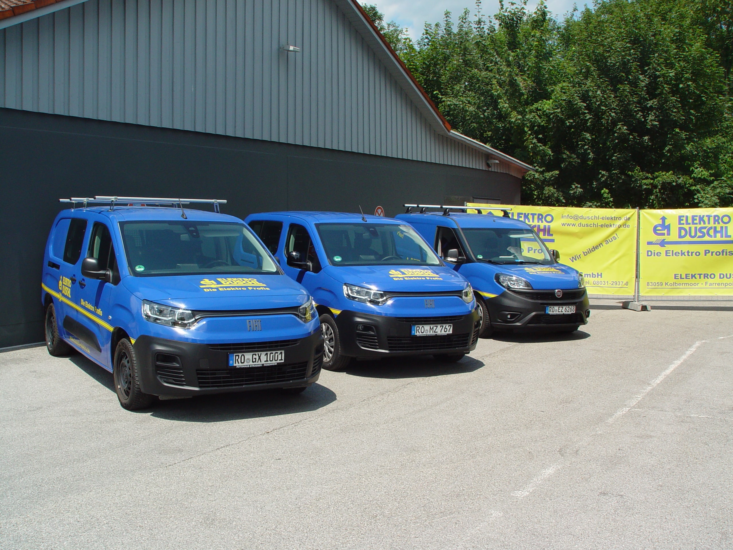 Firmenwägen Drei blaue Firmenwägen mit gelber Aufschrift